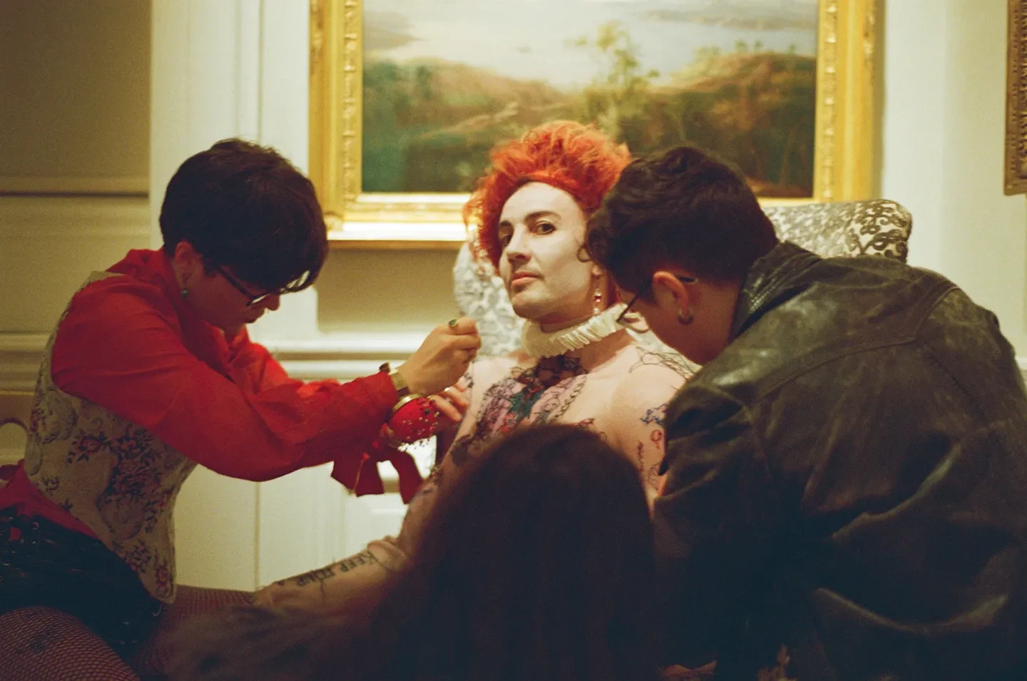 Two people using needles to sew 'tattoos' into a silicon torso worn by the artist E.M. Parry